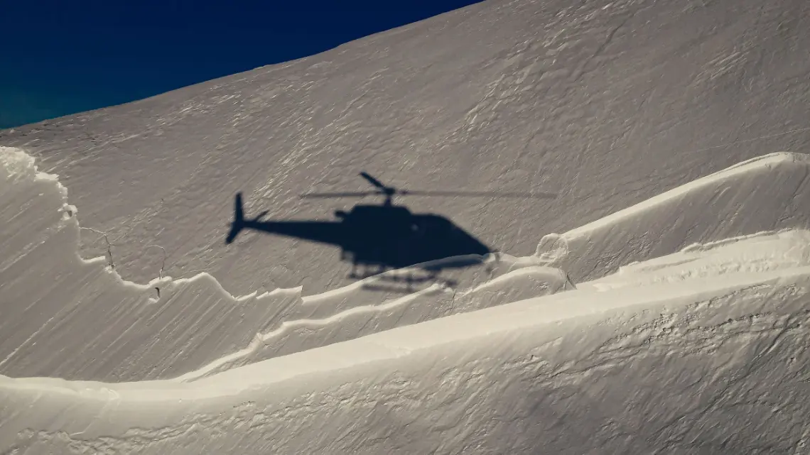 Shadow of a helicopter on a snowy slope