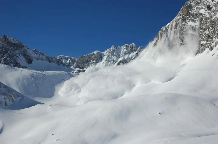 Snow cloud from an avalanche under a blue sky
